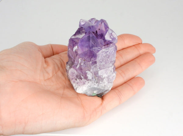 Beautiful Amethyst cluster with inclusions in someone's hand