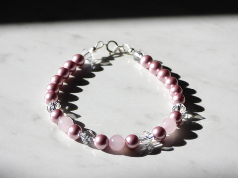 Pink princess bracelet with Swarovski pearls, swarovski crystals, rose quartz beads and sterling silver findings. View from slightly above, close up