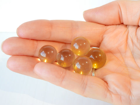 Multiple Star Citrine spheres in someone's hand, 3g size