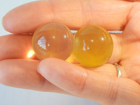 2 Star Citrine spheres in someone's hand, 13g size